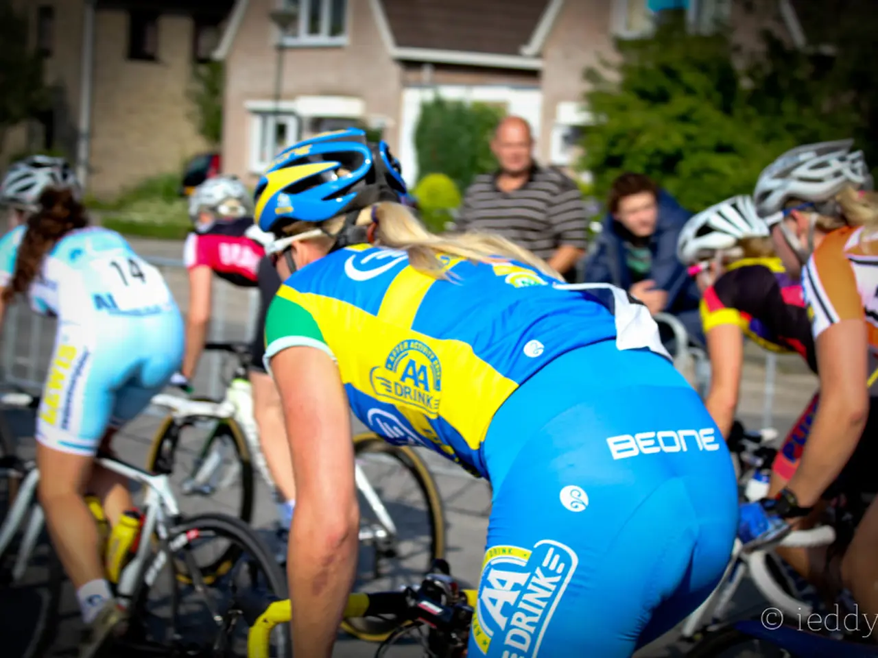 In this image I can see a few women riding their bicycles and two people watching them at the top...