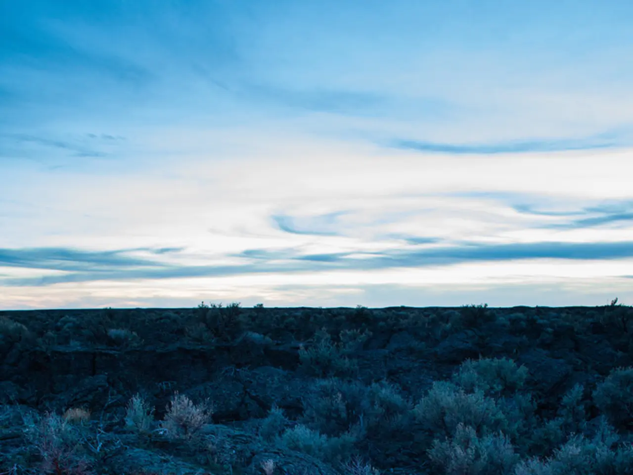 On the ground there is a camp fire. Around that some people are sitting and lying wearing caps. On...