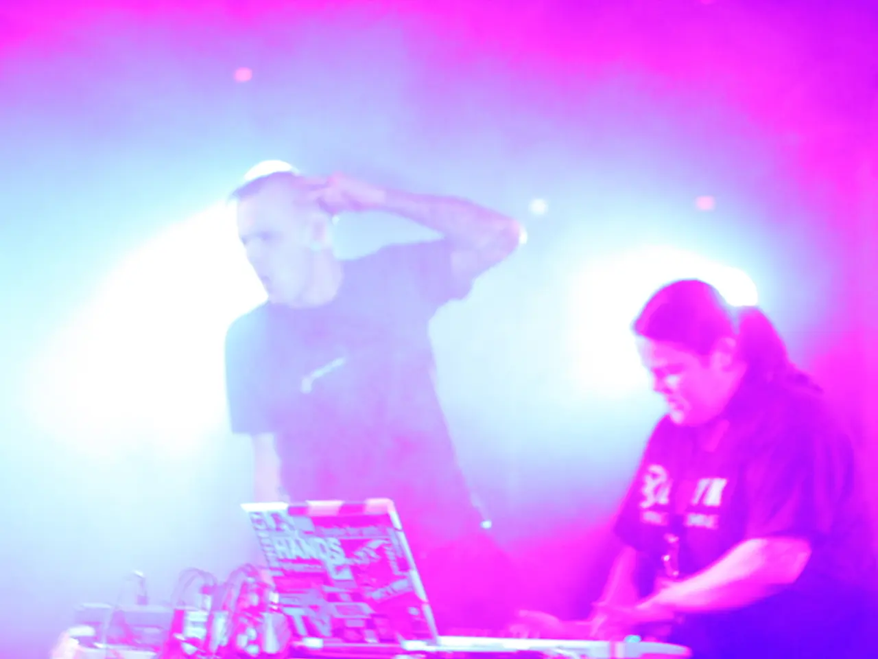 This image consists of two persons. On the right, the women wearing black T-shirt is playing the...