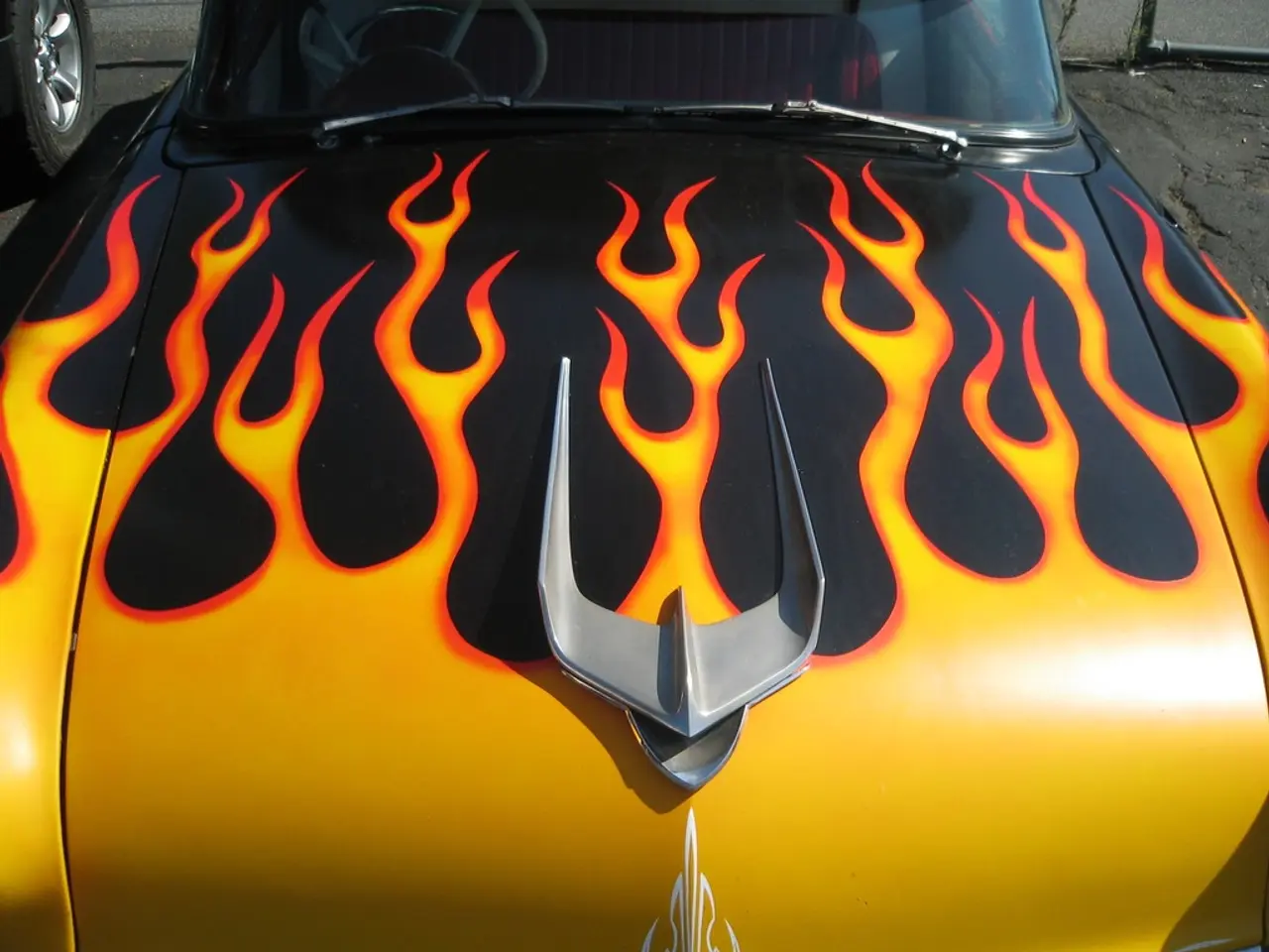 In this image there is a vehicle, beside it there is a tire of a vehicle.