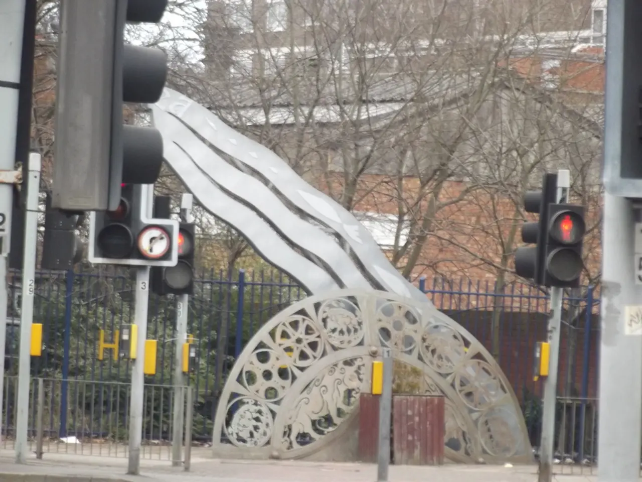 Here in this picture we can see traffic signal lights present on poles, which are present on road...