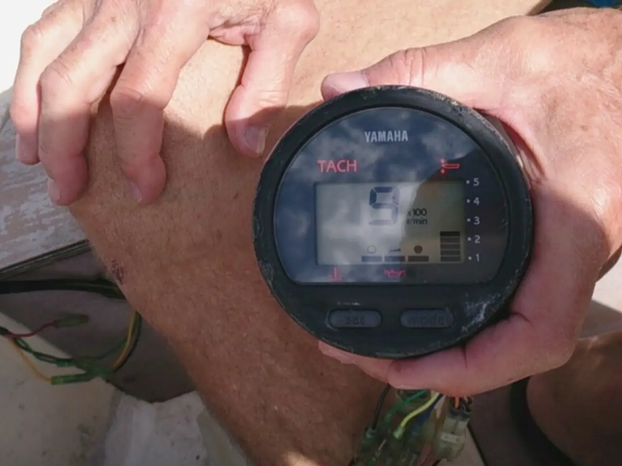 In this image there is a man who is holding the tachometer with the hand. At the bottom there are...