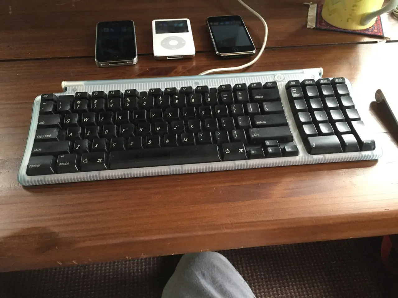 This picture shows a keyboard and a mobile and iPod on the table
