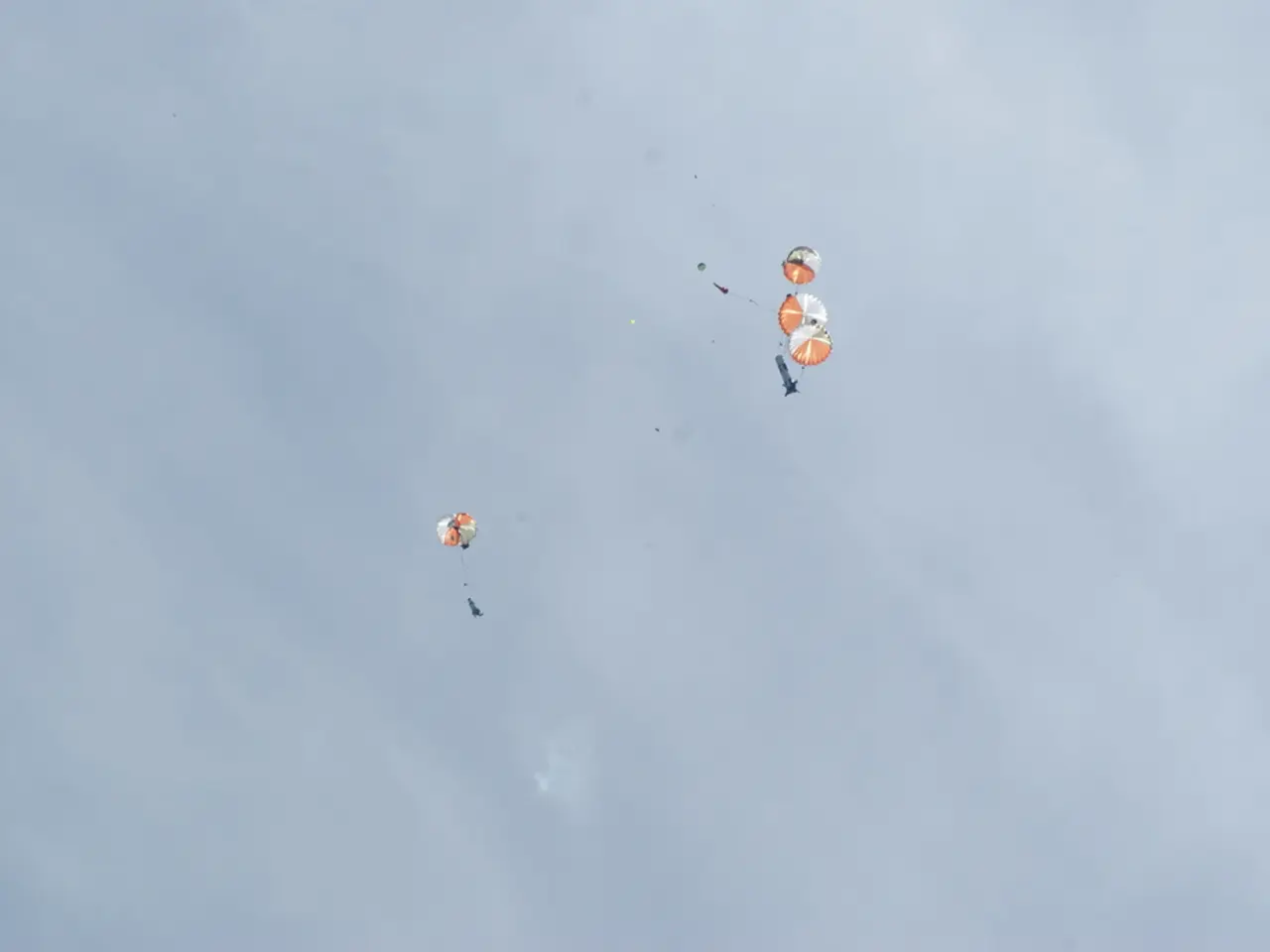 There are four parachutes flying in the sky.