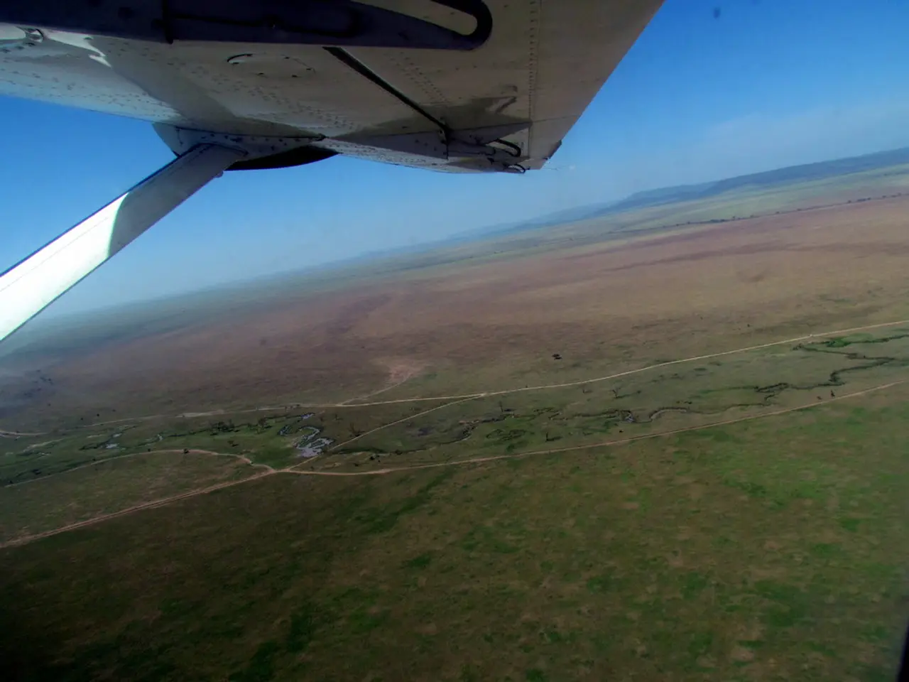 There is a white color aircraft, which is having a white color stand, flying in the air. Below...