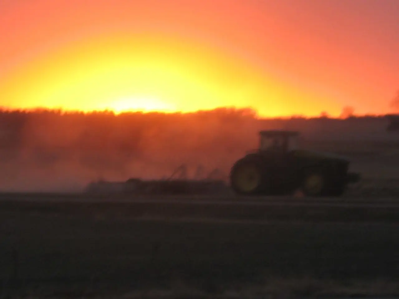 In this image there is a land, on that land there is a tractor, in the background there are trees...