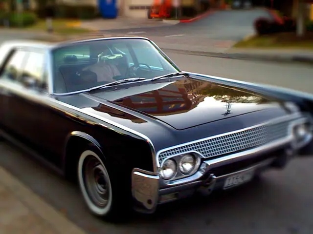 In this image we can see vehicles on the road and a blurry background.