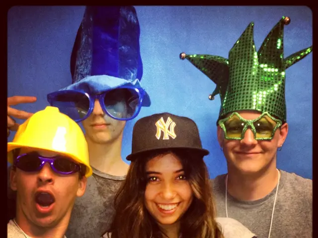 In this picture we can see four people wore caps, goggles and smiling and in the background it is...