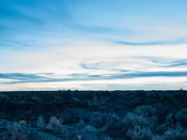 On the ground there is a camp fire. Around that some people are sitting and lying wearing caps. On...