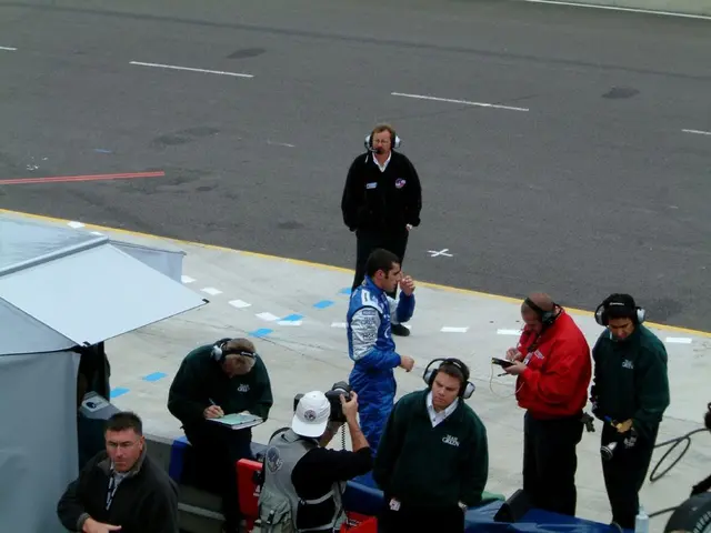 There are few people here standing and among them few wire headset to their ears and writing on the...