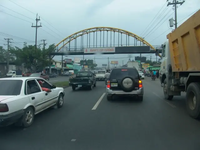 As we can see in the image there are cars, trucks, motorcycles, bridge, current polls, buildings,...