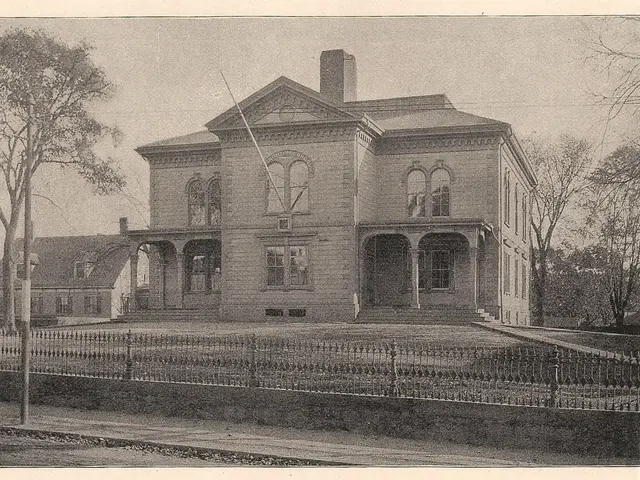 There is a fencing, pole, trees and buildings.
