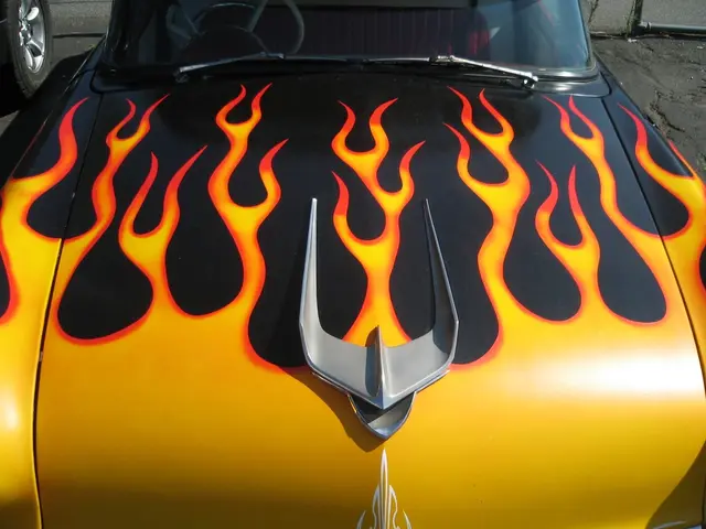 In this image there is a vehicle, beside it there is a tire of a vehicle.