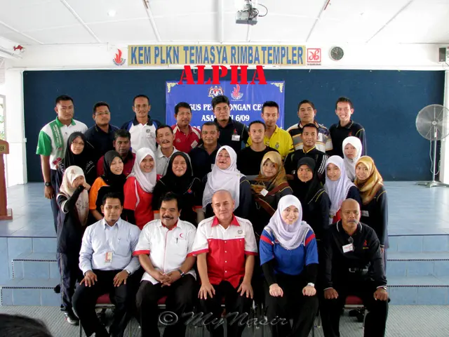 Here I can see a crowd of people smiling and giving pose for the picture. At the back of these...