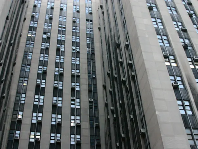 Here in this picture we can see a building with number of glass windows and AC present over there.