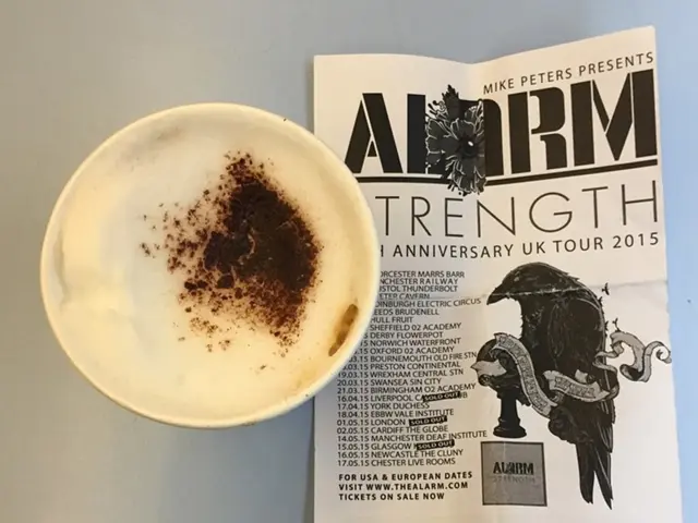 In this image there is a cup of coffee and a paper on the object.