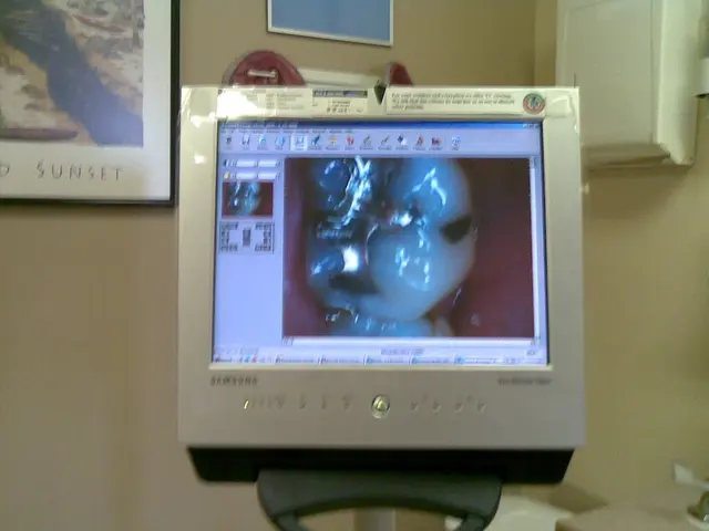 This picture shows a monitor and we see couple photo frames on the wall.